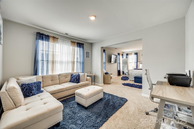 living room featuring carpet floors, visible vents, and baseboards