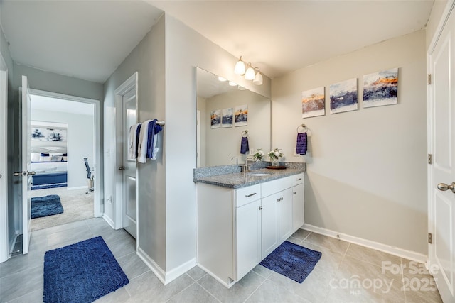 bathroom with tile patterned floors, baseboards, and vanity