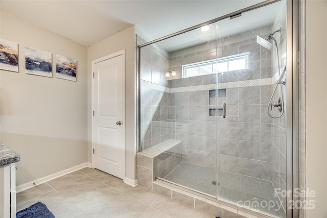 full bath featuring baseboards, a shower stall, vanity, and tile patterned floors