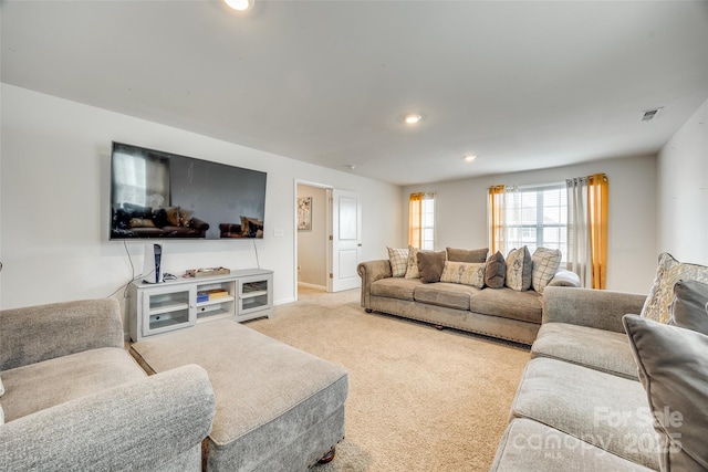 carpeted living area featuring baseboards, visible vents, and recessed lighting