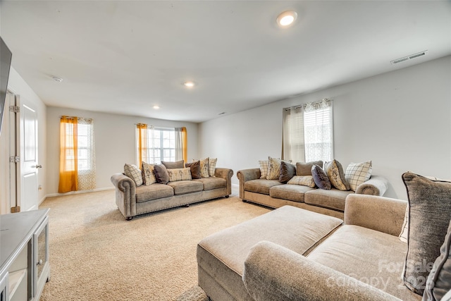 living area with recessed lighting, visible vents, baseboards, and light colored carpet