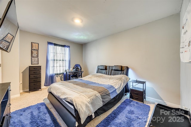 bedroom featuring baseboards and light colored carpet