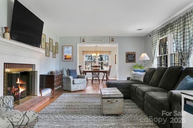 living area with a brick fireplace and wood finished floors