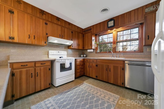 kitchen with under cabinet range hood, white appliances, a sink, visible vents, and light countertops