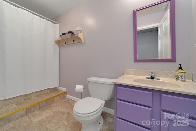 bathroom featuring toilet, baseboards, and vanity