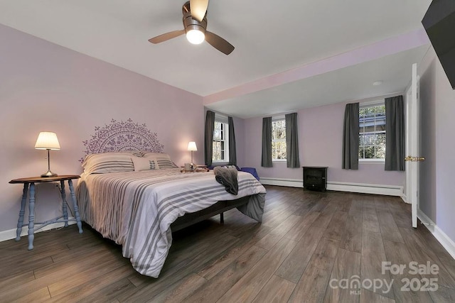 bedroom with baseboards, a baseboard heating unit, and wood finished floors