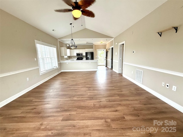 unfurnished dining area featuring ceiling fan with notable chandelier, a wealth of natural light, baseboards, and visible vents