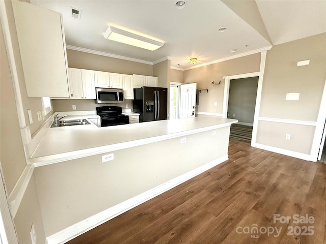 kitchen featuring a peninsula, a sink, crown molding, light countertops, and black appliances