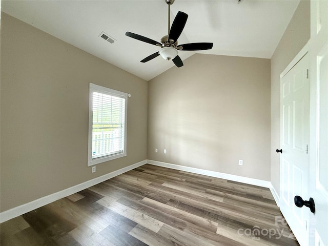 unfurnished bedroom featuring a ceiling fan, wood finished floors, baseboards, lofted ceiling, and visible vents