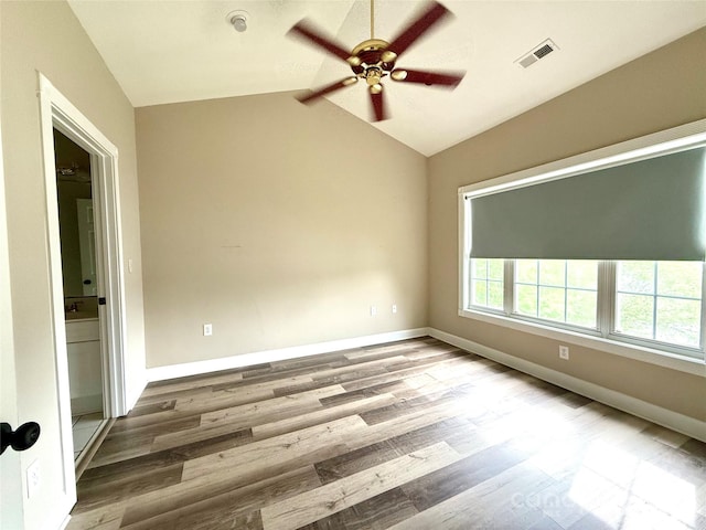 unfurnished room featuring ceiling fan, lofted ceiling, wood finished floors, and visible vents