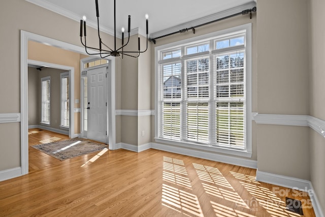 foyer entrance featuring light wood-type flooring, baseboards, and crown molding