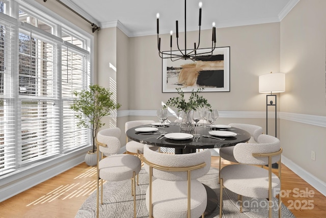 dining space featuring baseboards, ornamental molding, a wealth of natural light, and light wood-style floors