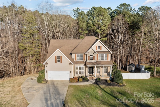 traditional home with concrete driveway, a porch, an attached garage, fence, and a front lawn