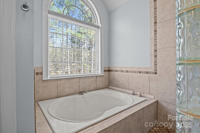 bathroom with vaulted ceiling and a garden tub