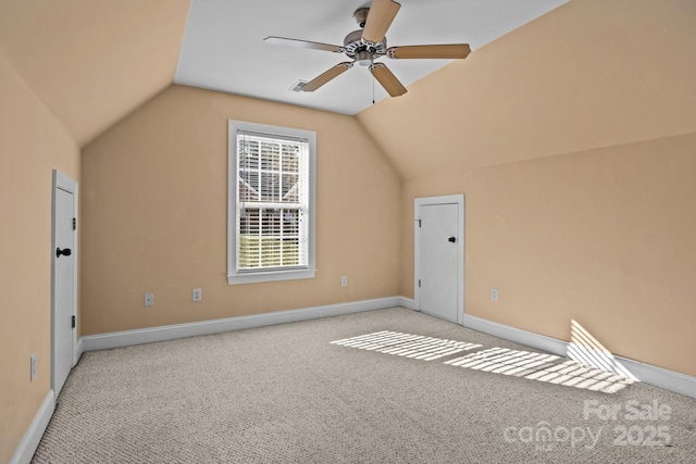 bonus room with light carpet, vaulted ceiling, a ceiling fan, and baseboards