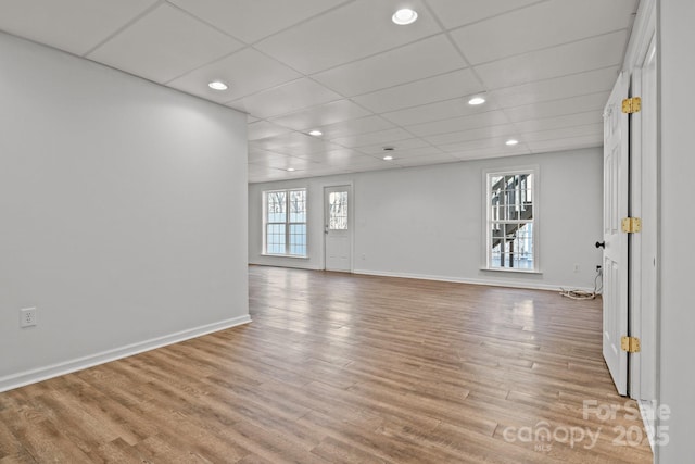 unfurnished room featuring a paneled ceiling, light wood-style floors, baseboards, and recessed lighting