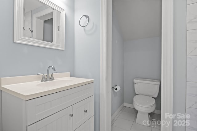 bathroom with tile patterned flooring, baseboards, vanity, and toilet