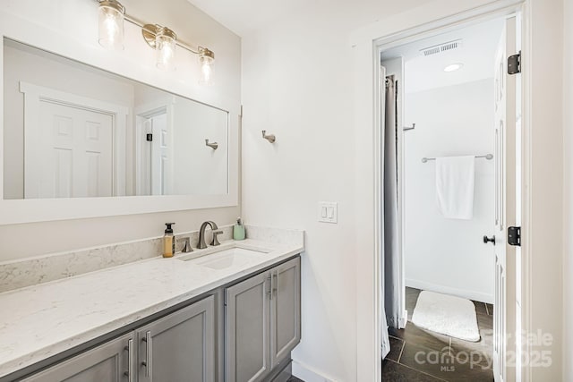 bathroom with baseboards, visible vents, and vanity