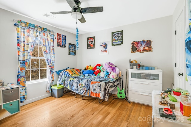 bedroom featuring light wood-type flooring, visible vents, and a ceiling fan