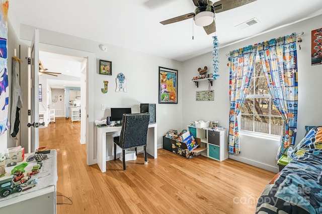 office space featuring light wood-style floors, visible vents, ceiling fan, and baseboards