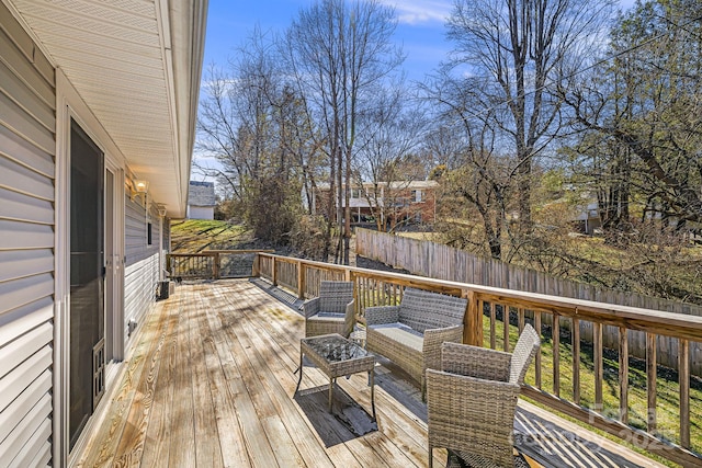 wooden terrace with outdoor lounge area and fence