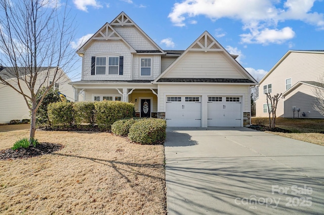 craftsman-style house featuring driveway, stone siding, and a garage