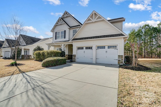 craftsman-style home featuring a garage, stone siding, and driveway