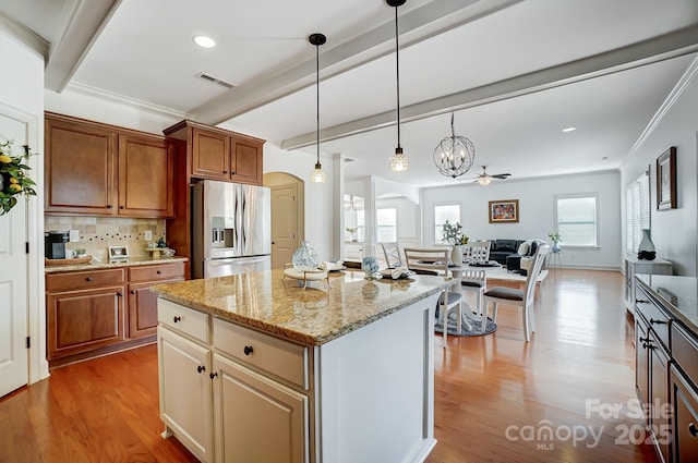 kitchen featuring arched walkways, visible vents, open floor plan, stainless steel fridge with ice dispenser, and beamed ceiling