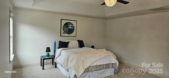 carpeted bedroom with a ceiling fan, baseboards, visible vents, a raised ceiling, and crown molding