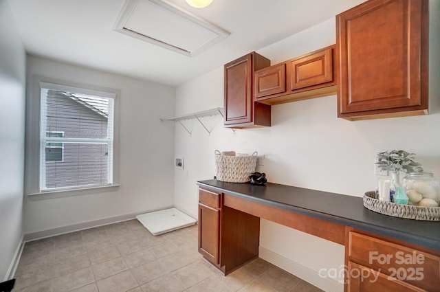 office area featuring attic access, baseboards, and built in desk