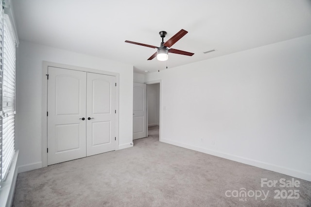 unfurnished bedroom with a closet, carpet flooring, visible vents, and baseboards