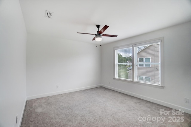 empty room with ceiling fan, carpet, visible vents, and baseboards