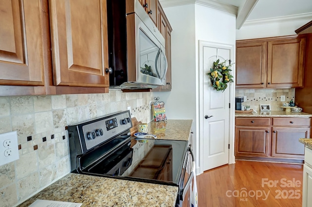 5006 Sand Trap Ct Unit 142, Monroe, NC 28112 - kitchen featuring appliances with stainless steel finishes, tasteful backsplash, light stone countertops, brown cabinetry, and crown molding