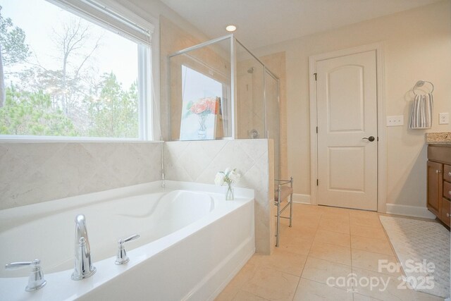 5006 Sand Trap Ct Unit 142, Monroe, NC 28112 - bathroom featuring vanity, a bath, a stall shower, and healthy amount of natural light
