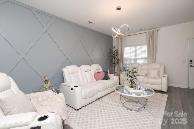 living area with baseboards, visible vents, and wood finished floors