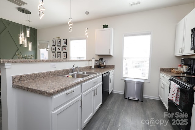 kitchen featuring visible vents, black appliances, white cabinetry, pendant lighting, and a sink