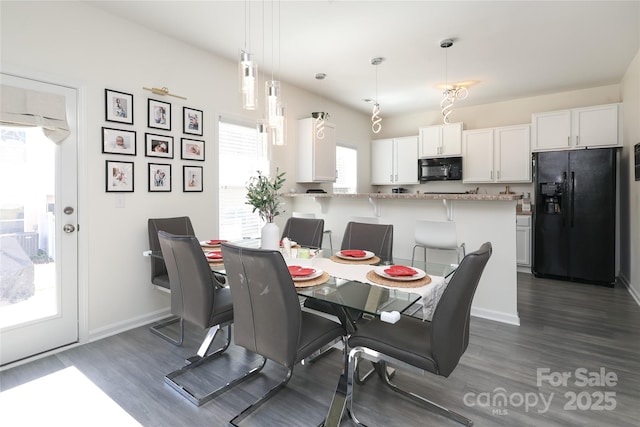 dining room featuring dark wood-style flooring and baseboards