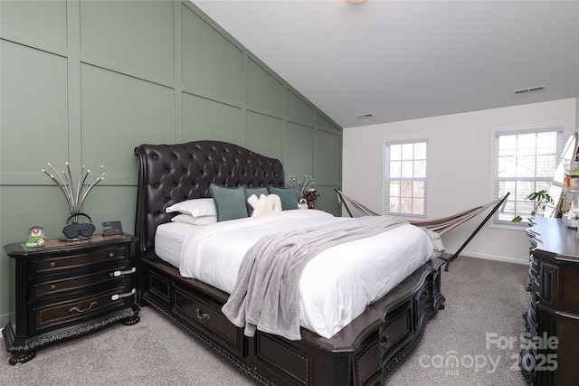 bedroom with lofted ceiling, visible vents, and light colored carpet