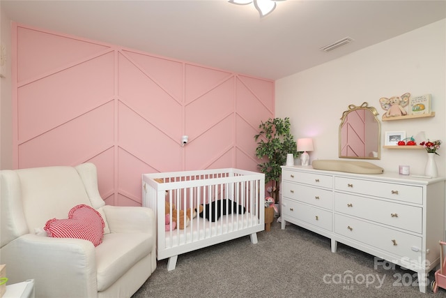 carpeted bedroom featuring a nursery area, visible vents, and a decorative wall