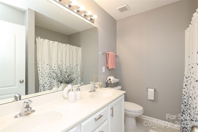 full bathroom with toilet, double vanity, a sink, and visible vents