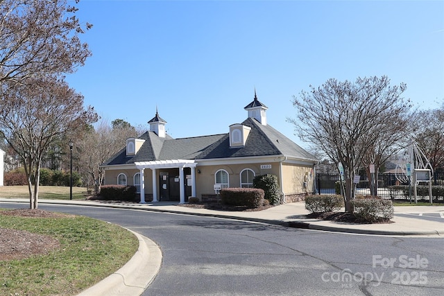 view of property featuring driveway and fence