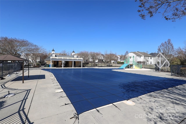 view of swimming pool with playground community, a gazebo, and fence