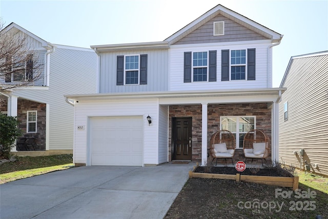 traditional home featuring concrete driveway, a porch, board and batten siding, and stone siding