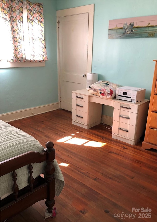 bedroom with baseboards and wood finished floors