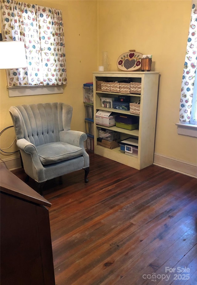 living area featuring baseboards and wood finished floors