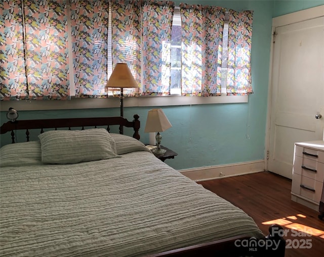 bedroom featuring baseboards and wood finished floors