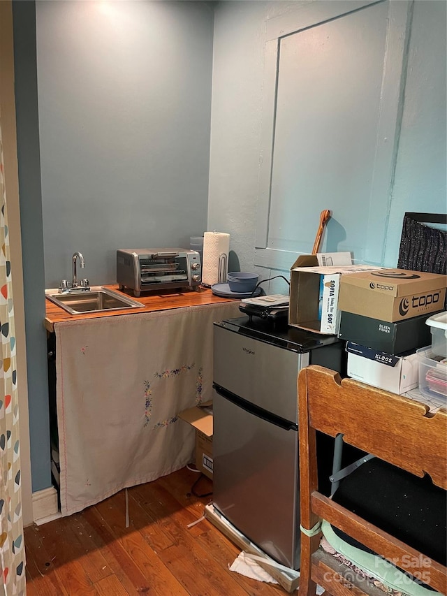 office with hardwood / wood-style floors, a sink, and a toaster