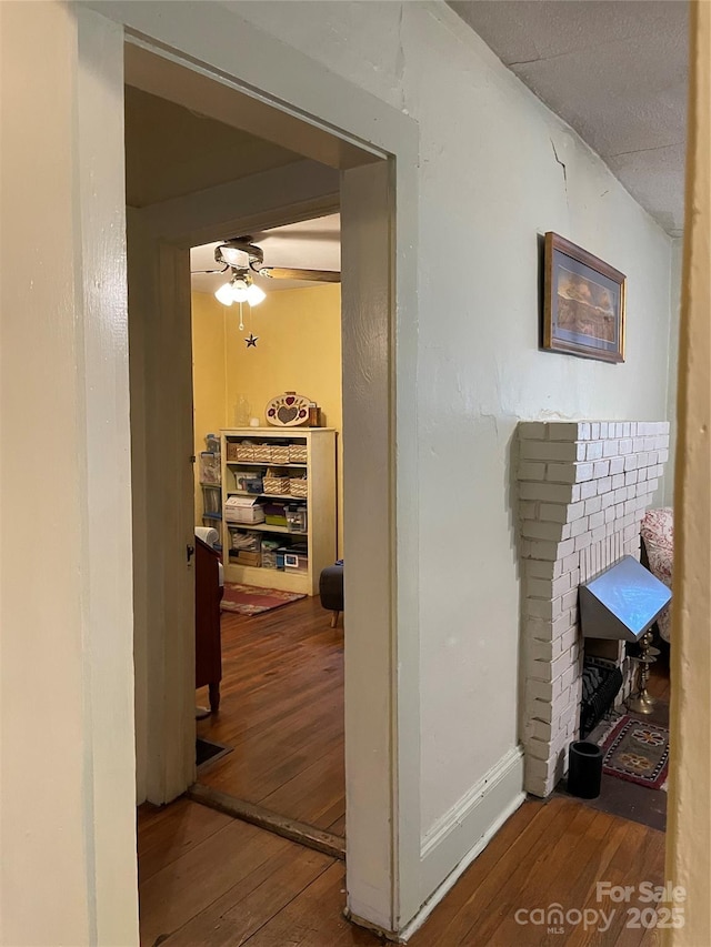 hallway featuring baseboards and hardwood / wood-style floors