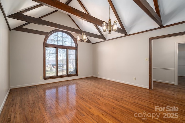 spare room featuring baseboards, visible vents, an inviting chandelier, and wood finished floors