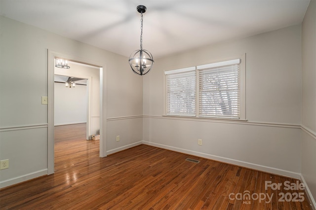 spare room with visible vents, baseboards, and dark wood-style flooring